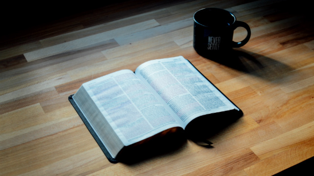 桌子上面放着一本圣经和一个水杯