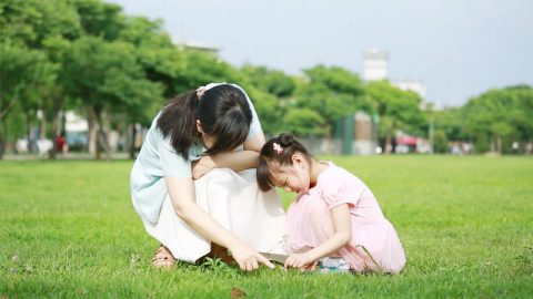 基督徒妈妈和孩子在草坪上玩耍